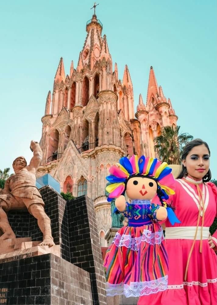 San Miguel Arcangel Church Facade, Woman wearing typical dress with a Lele Doll